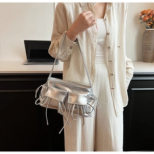 Close-up of a silver metallic PU shoulder bag with dual flap pockets and straps
