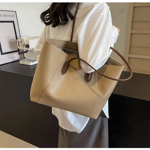 Detail view of khaki tote bag with slim dark brown handles and spacious interior