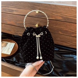 Detail of black velvet bucket bag with white dots, silver chain and pearl drawstrings