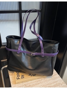 Black leather tote bag with purple straps and silver buckle in minimalist style
