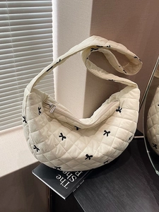 Quilted beige half-moon shoulder bag with black bow embroidery and wide strap design