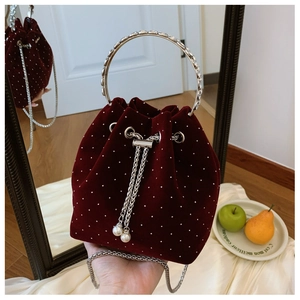 Detail of burgundy velvet bucket bag with sparkling dots and pearl drawstring chain