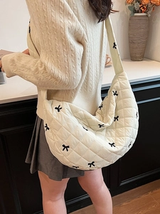 Off-white quilted half-moon shoulder bag featuring cute black bow embroidery accents