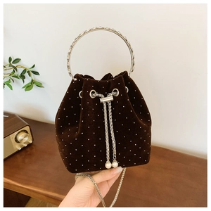 Detail of velvet bucket bag with sparkling rhinestones, metal ring handle and pearl chain