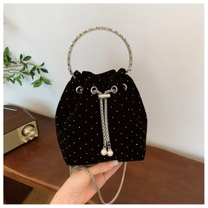 Detail of velvet bucket bag featuring silver rhinestones and elegant pearl drawstring accents
