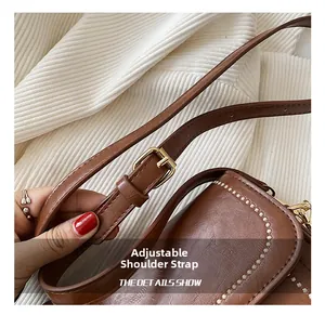 Détail du sac en cuir marron avec bandoulière réglable et boucle en métal doré chic