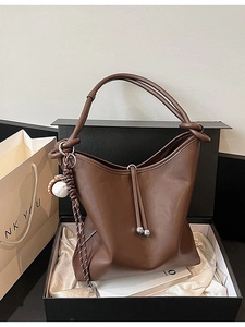 Borsa tote in morbida pelle marrone con tracolla annodata e ciondolo da baseball