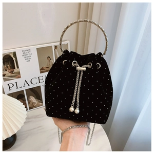 Detail of black velvet bucket bag with rhinestone studs and pearl drawstring charm