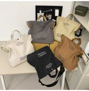 Flat lay of canvas tote bags in five colors with leisurely text and shoulder straps