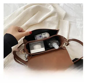 Vue intérieure des compartiments et capacité de rangement du sac bandoulière en cuir PU