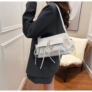 Side view of white patent leather baguette bag featuring bow knots and flap pockets