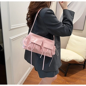 Pink glossy faux leather shoulder bag with functional cargo pockets and drawstring details
