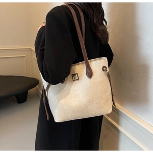 Detail der minimalistischen cremefarbenen Shopper-Tasche mit Lederstruktur und Kordelzug