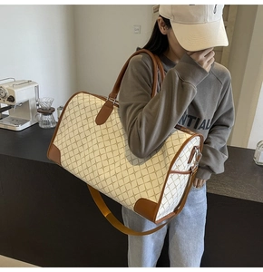 Große Reisetasche mit braunem Lederbesatz und Retro-Karomuster in der Detailansicht