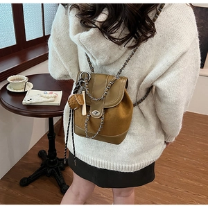 Detailed view of the matte brown backpack with metal chain strap and twist lock