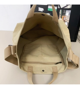 Top view of khaki canvas tote showing interior compartments and adjustable strap