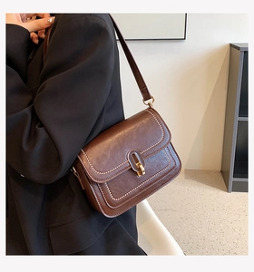 Détail du sac bandoulière vintage en cuir PU marron avec bordure dorée et boucle en métal