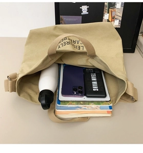 Interior view showing large capacity of the khaki canvas tote with tablet and books