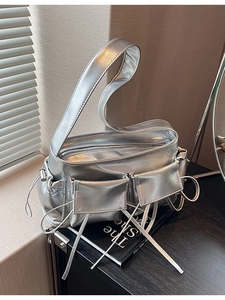 Silver metallic shoulder bag with multi-pocket utility design and drawstring accents