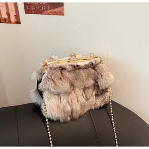 Dettaglio borsa a tracolla in peluche con catena a sfere dorate e chiusura a sfere