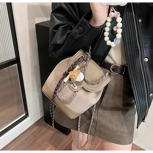 Detail of frosted mini bucket backpack with chain strap and sporty baseball pendant charm