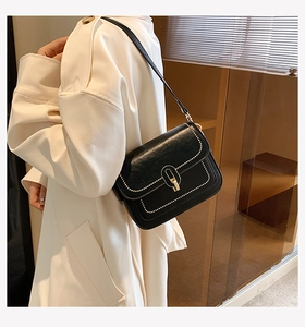 Détails du petit sac en cuir noir avec surpiqûres blanches et boucle en métal doré