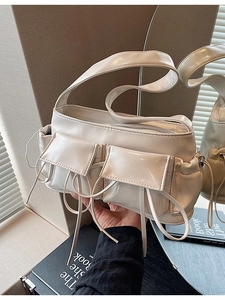 Cream bow pleated baguette bag with side pockets and decorative drawstring handles