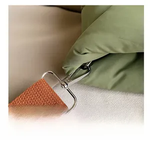 Close-up of durable metal hook and orange woven strap on a green quilted bucket bag