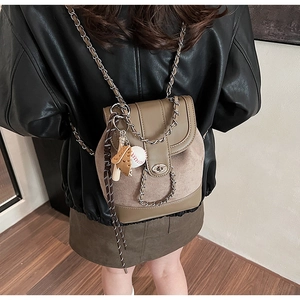 Detail shot of khaki matte leather mini backpack with chain strap and sports pendant