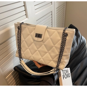 Détail du sac cabas matelassé blanc avec chaîne noire et fermoir rotatif métallique