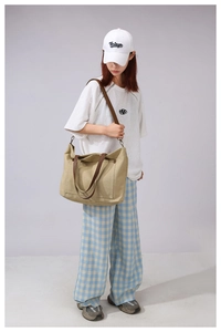 Detail of a large khaki canvas tote bag with brown straps for casual daily use