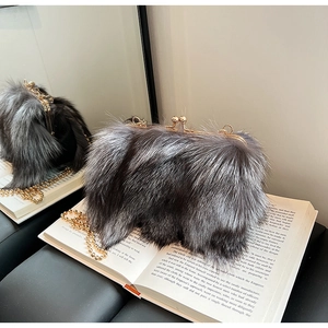Dettaglio borsa in peluche grigia con chiusura a scatto dorata e tracolla a catena