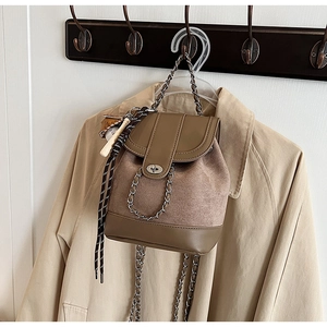 Detail of retro mini backpack with suede panels, silver chain and metal twist lock