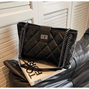 Détail du sac cabas matelassé noir avec coutures en losanges et bandoulière