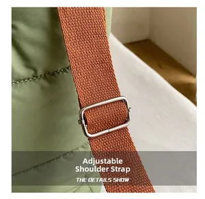 Close-up of adjustable woven shoulder strap with metal buckle on green quilted bucket bag