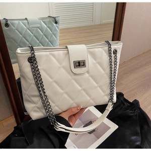 Détail d'un sac cabas matelassé blanc avec motif de losanges et bandoulière chaîne