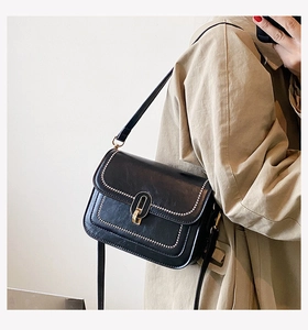 Détail du sac à bandoulière en cuir PU noir avec clous dorés et fermoir métallique