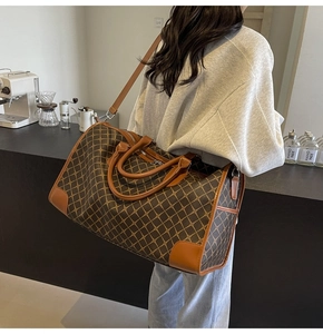 Details der großen braunen Reisetasche mit Seitentasche und Ledergriff im Fokus