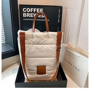 White quilted puffer tote bag detail with brown leather straps and square patch