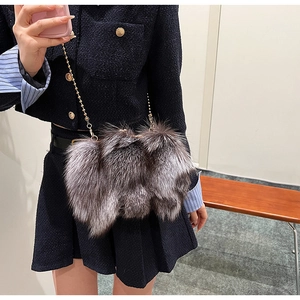 Détail du sac à bandoulière en peluche gris argenté avec chaîne dorée sur modèle