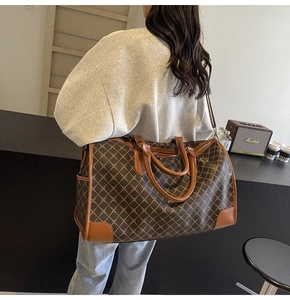 Große Reisetasche mit Vintage-Geometriemuster und Seitentasche an einem Modell
