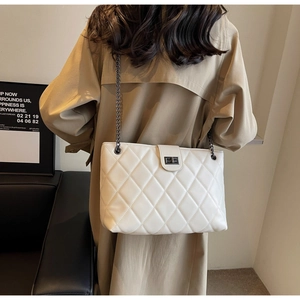 Détail d'un grand sac cabas blanc matelassé avec bandoulière chaîne sur un mannequin