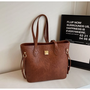 Detailansicht der dunkelbraunen Leder-Shopper-Tasche mit Narbenstruktur und Goldmetallschnallen