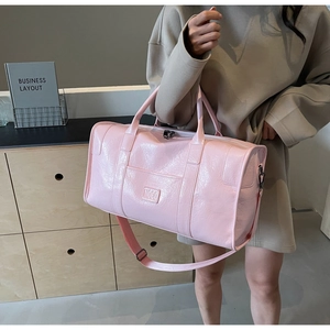 Primer plano de la bolsa de viaje rosa con elegante grabado de logotipo en relieve