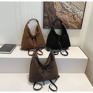 Detail of matte texture shoulder bags with decorative leather bows and round handles