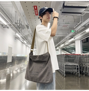 Detail of grey canvas messenger bag showing heavy-duty fabric and adjustable strap