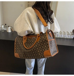 Makro-Detail braune Reisetasche mit Karomuster, PU-Leder-Textur und Schultergurt-Design