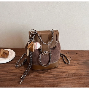 Detailed close-up of a retro brown frosted mini backpack with chain strap and baseball charm