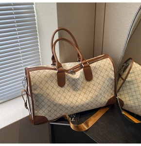 Detailansicht der großen Reisetasche mit braunem Retromuster und Ledergriffen