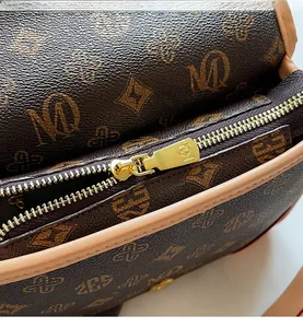 Detailansicht des goldenen Metallreißverschlusses und Vintage Monogramms der Tasche